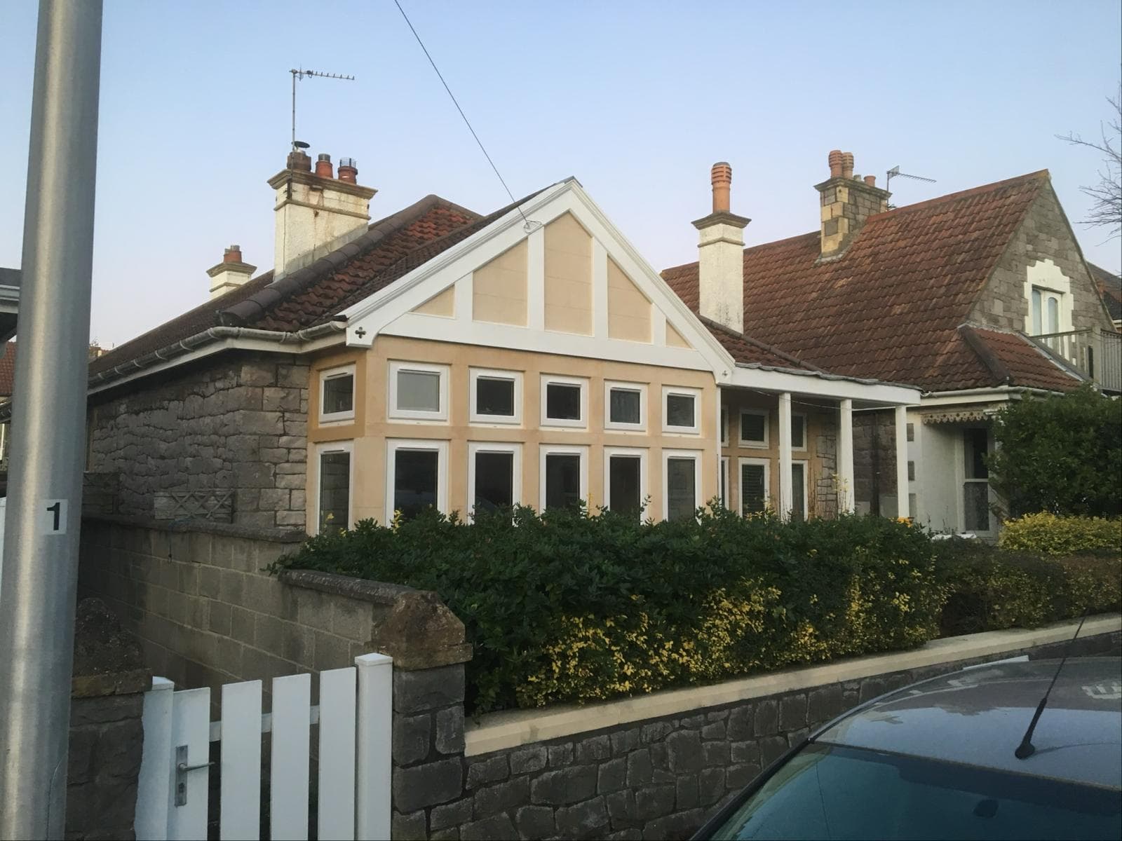 Weathered bay window and gable of a Victorian property mid-restoration, with new bathstone surrounds installed